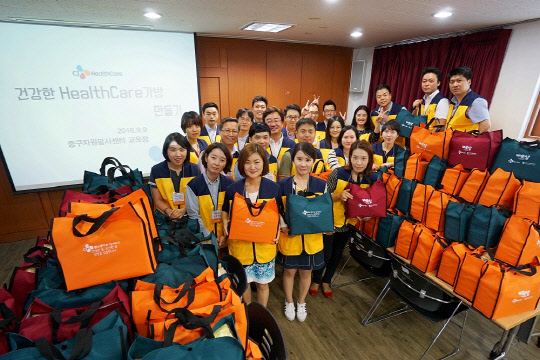 CJ헬스케어 임직원들은 지난 9일 서울 중구자원봉사센터에서 '독거 어르신을 위한 H-bag 제작' 봉사를 진행했다. 봉사에 참여한 임직원들이 완성된 H-bag 앞에서 기념사진을 찍고 있다.(CJ헬스케어 제공)